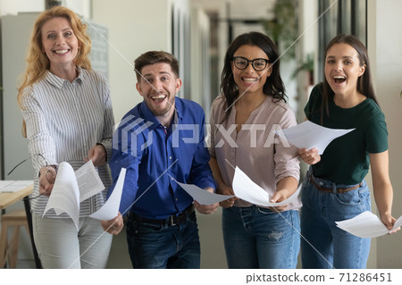 Group portrait of laughing excited business team showing confirmed contract 71286451