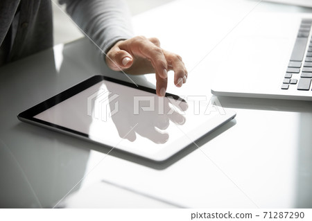 Young female holding hand over digital tablet with white screen 71287290