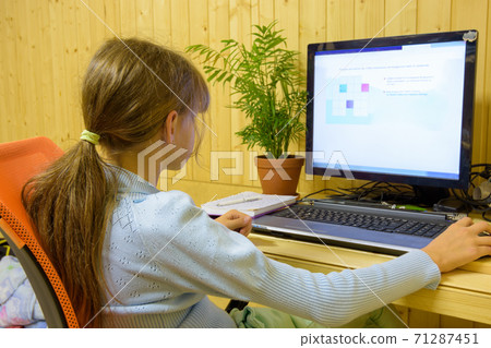 A student passes distance learning tasks on a computer 71287451
