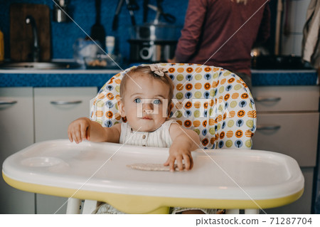 Baby Feeding. Best Finger Foods for toddler Babies. Toddler baby girl with Crispbread, Cereal Crackers sitting in feeding chair 71287704