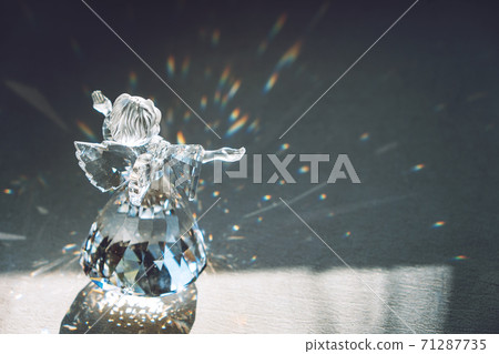 Crystal glass angel in the rays of the sun with reflecting, embossed sparkle. Faith, hope, mercy concept 71287735