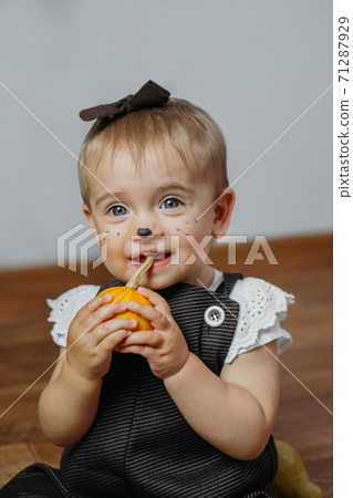 Halloween Thanksgiving Makeup Ideas for Kids and Baby. Happy funny baby with a pumpkin on home background Halloween Thanksgiving Makeup Ideas for Kids and Baby. Happy funny baby with a pumpkin on home background 71287929