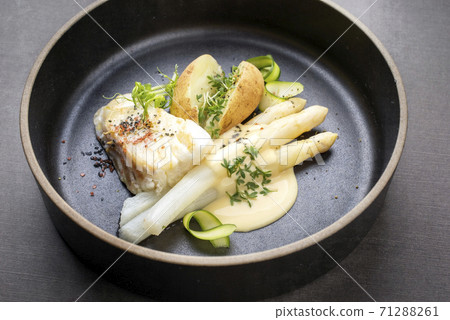 German fried cod fish filet with white asparagus in sauce hollandaise und roast potatoes German fried cod fish filet with white asparagus in sauce hollandaise und roast potatoes 71288261