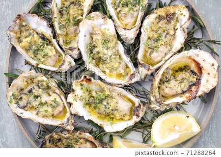 overbaked fresh opened oyster with garlic, lemon and herbs 71288264