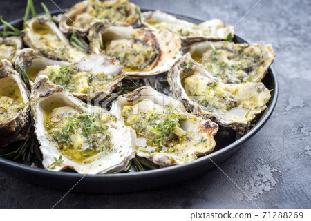 overbaked fresh opened oyster with garlic, lemon and herbs overbaked fresh opened oyster with garlic, lemon and herbs 71288269
