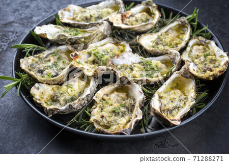 overbaked fresh opened oyster with garlic, lemon and herbs 71288271
