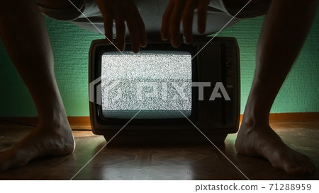 Man sitting on old television 71288959