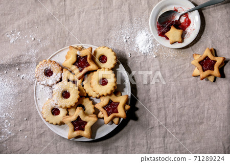 Linz shortbread biscuits cookies with jam on linen tablecloth. Flat lay Linz shortbread biscuits cookies with jam on linen tablecloth. Flat lay 71289224