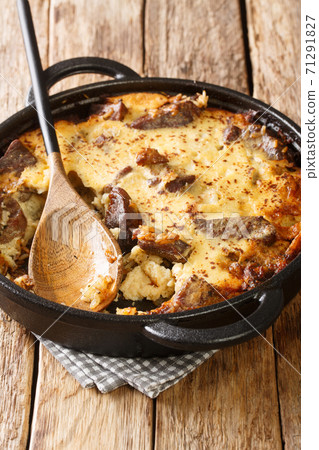 Albanian lamb and rice Tave kosi casserole baked with a mixture of yoghurt and eggs close-up in a pan. vertical Albanian lamb and rice Tave kosi casserole baked with a mixture of yoghurt and eggs close-up in a pan. vertical 71291827