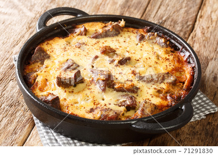 Albanian Baked Lamb and Rice with Yogurt Tave Kosi close-up in a pan. horizontal 71291830