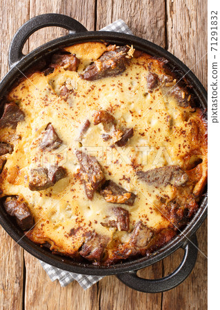 Tave kosi soured milk casserole of lamb and rice baked with a mixture of yogurt and eggs closeup in the pan. vertical top view 71291832