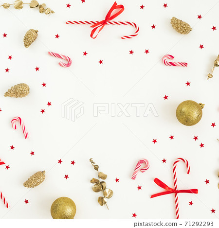Christmas winter composition. Golden decoration with confetti and candy canes on white. Flat lay, top view. New Year holiday Christmas winter composition. Golden decoration with confetti and candy canes on white. Flat lay, top view. New Year holiday 71292293