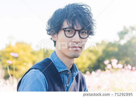 一個年輕人在波斯菊領域中微笑 71292895