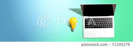 Laptop computer with a yellow light bulb 71295279