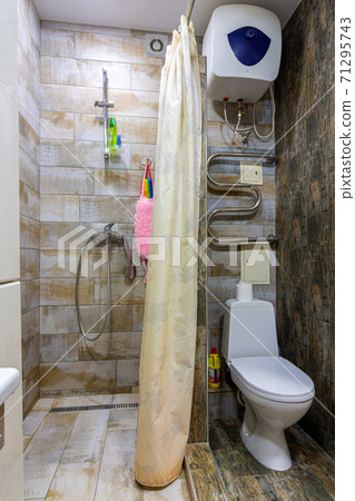 Small compact bathroom divided with shower curtain and toilet Small compact bathroom divided with shower curtain and toilet 71295743