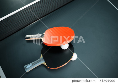 Ping pong rackets and ball at the net closeup Ping pong rackets and ball at the net closeup 71295900
