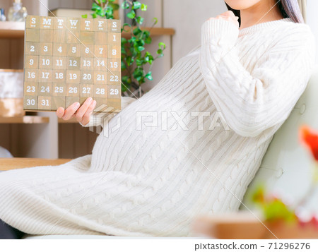 Pregnant woman looking at the calendar Thinking 4: 3 71296276