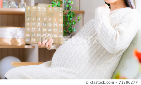 Pregnant woman looking at the calendar Think 16: 9 71296277