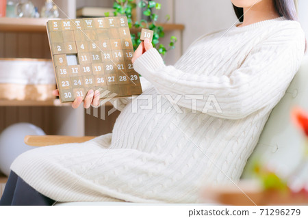 Pregnant women looking at the calendar 71296279