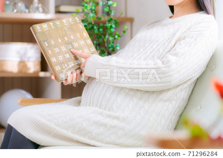 See the calendar Pregnant women pointing and counting 71296284