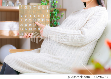 See the calendar Pregnant women pointing and counting 71296287