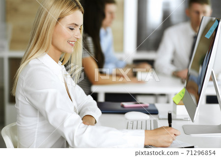 Business woman using computer at workplace in modern office. Secretary or female lawyer smiling and looks happy. Working for pleasure and success Business woman using computer at workplace in modern office. Secretary or female lawyer smiling and looks happy. Working for pleasure and success 71296854