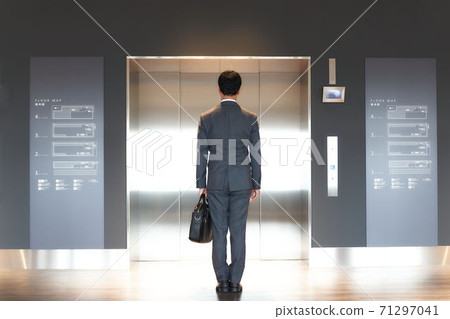 Men in suits waiting for the elevator 71297041