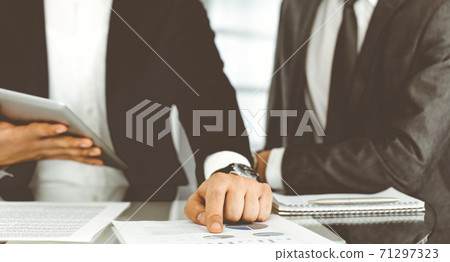 Business people using tablet computer while working together in modern office. Unknown businessman sitting at the desk with his colleague or partner. Teamwork and partnership concept Business people using tablet computer while working together in modern office. Unknown businessman sitting at the desk with his colleague or partner. Teamwork and partnership concept 71297323