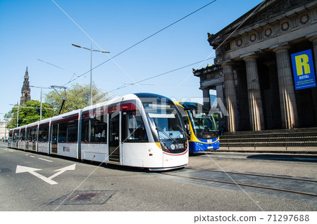 在晴朗的天空下，一輛有軌電車穿過愛丁堡的街道 71297688