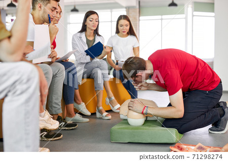 CPR class with caucasian instructors speaking and demonstrating help first aid CPR class with caucasian instructors speaking and demonstrating help first aid 71298274