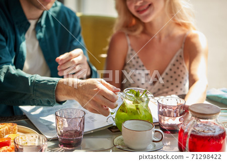 male is going to pour sweet beverage into glasses for woman male is going to pour sweet beverage into glasses for woman 71298422