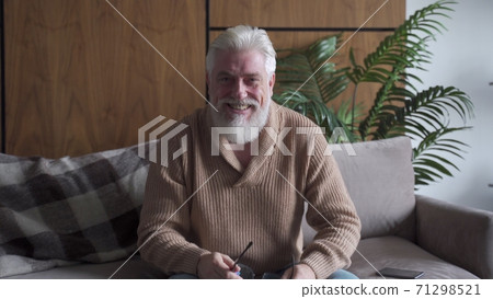 Happy senior old grey haired man with a gray beard talking to webcam make call, smiling mature blogger recording, looking at camera, elderly people online communication at home 71298521