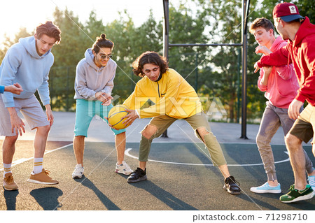 group of young male teenagers playing basketball outdoors group of young male teenagers playing basketball outdoors 71298710