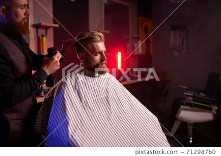 haircut at the hairdresser, in salon. barber male cuts the hair on the handsome young client's head 71298760