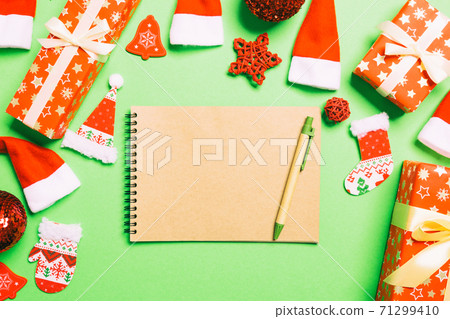 Top view of notebook on green background made of Christmas decorations. New Year time concept 71299410