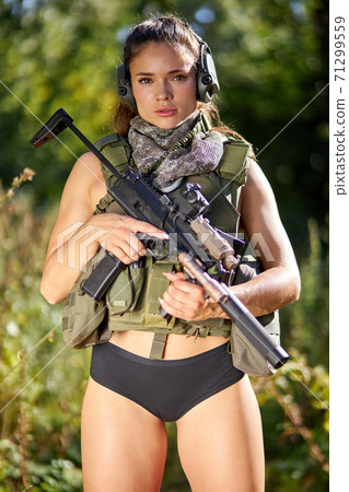 portrait of confident military woman with a gun in forest portrait of confident military woman with a gun in forest 71299559