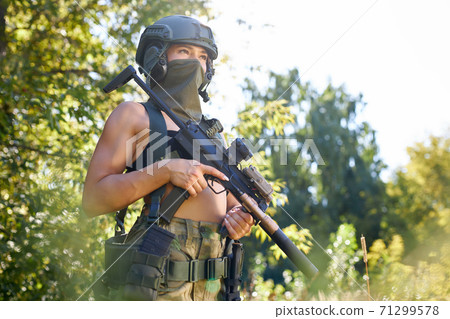 attractive brave military woman with a gun in forest, survival in wild forest attractive brave military woman with a gun in forest, survival in wild forest 71299578