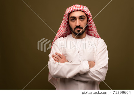 Muslim man. Portrait of a young arab man in traditional dress.  71299604