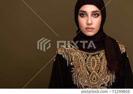 Muslim woman in hijab. Portrait of a young arab girl in traditional dress.  71299608