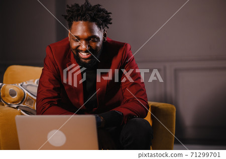 a black man works at a laptop close-up of his face. video conferences 71299701