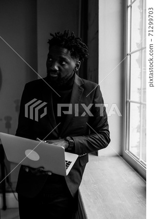 a black man works at a laptop close-up of his face. video conferences 71299703