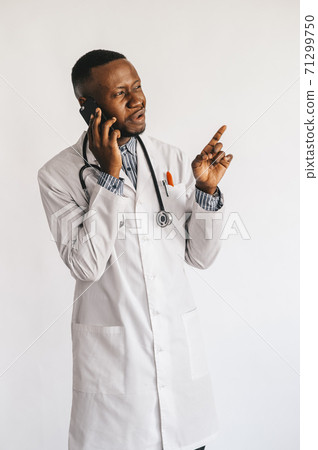 Closeup picture of young African American doctor standing in white uniform against white background Closeup picture of young African American doctor standing in white uniform against white background 71299750
