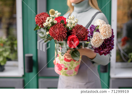 people, business, sale and floristry concept - close up of florist woman holding bunch at flower shop people, business, sale and floristry concept - close up of florist woman holding bunch at flower shop 71299919