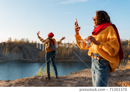 Girls take a selfie on the background of autumn nature 71301378