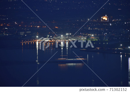 Take a picture of the ferry going from Mt. Hakodate, Hakodate City, Hokkaido to the ferry terminal in Hakodate Bay at dawn. Take a picture of the ferry going from Mt. Hakodate, Hakodate City, Hokkaido to the ferry terminal in Hakodate Bay at dawn. 71302152
