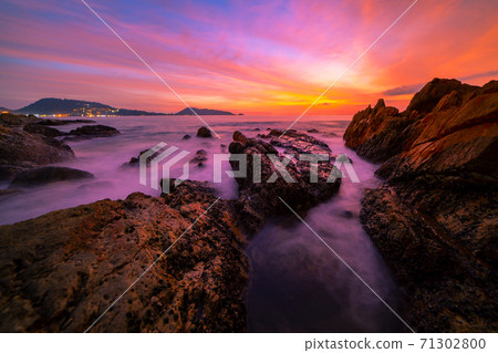 Long exposure image of Dramatic sky seascape with rocks in the foreground sunset or sunrise over sea scenery background. Long exposure image of Dramatic sky seascape with rocks in the foreground sunset or sunrise over sea scenery background. 71302800