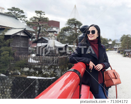 Happy woman tourist enjoy view in Red Nakabashi Bridge of Takayama, Japan 71304172