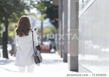 在戶外的智能手機後方的女人 71304600