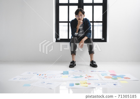Young hipster asian man thinking and sitting side window in white room 71305185