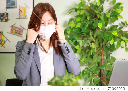 Business woman trying to remove the mask 71306923